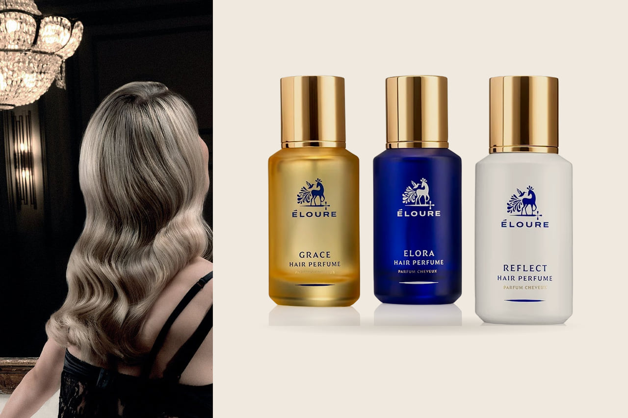 Left, long glossy blonde waves seen from behind beneath a crystal chandelier; right, three Maison Éloure hair perfume bottles on a warm stone ground.